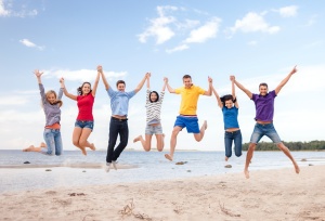 group of friends jumping on the beach